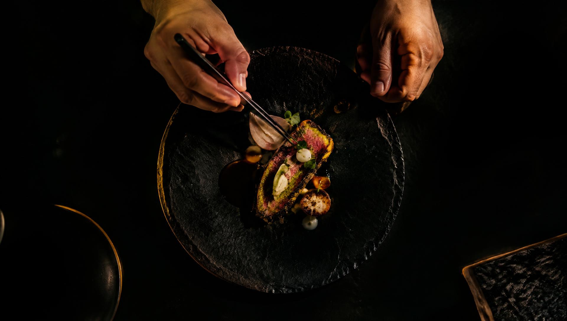 Chef plating a dish with tweezers